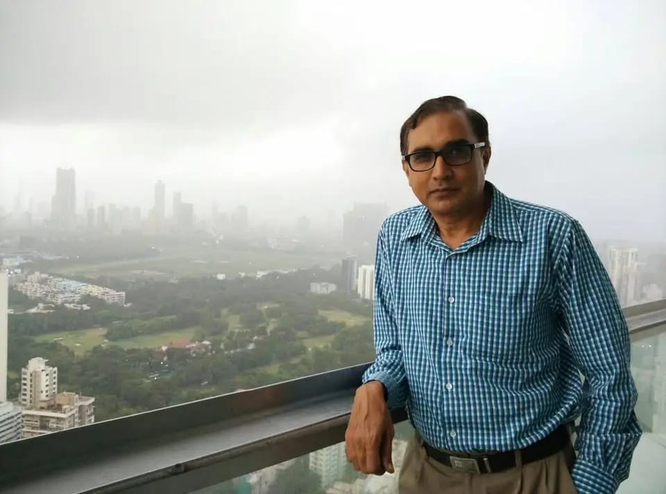 B.S. Kumaraswamy with city view from balcony